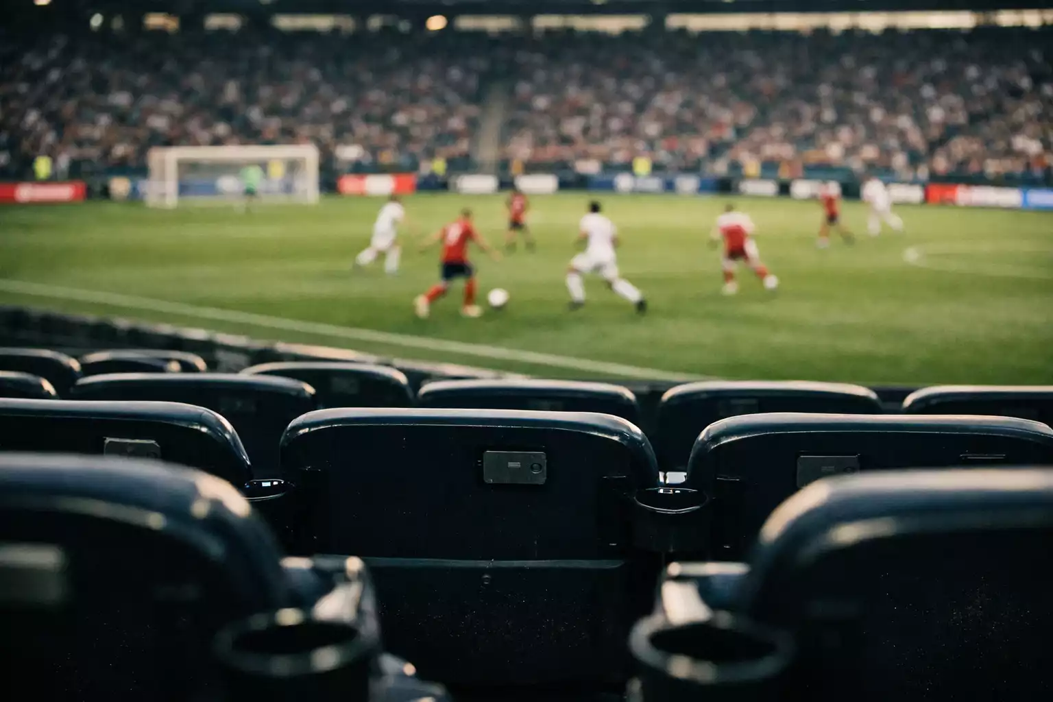 Football match viewed through stadium seats with data graphics